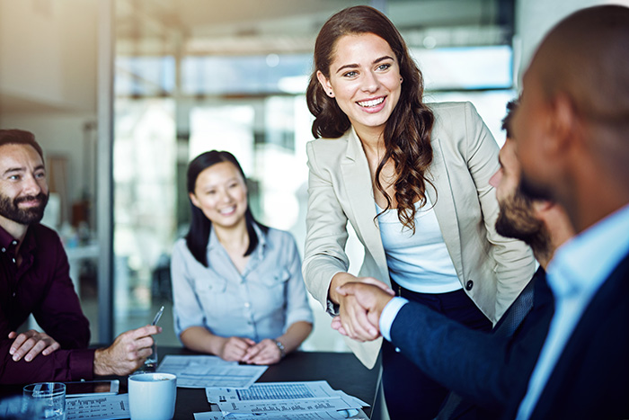 smiling woman in room with team